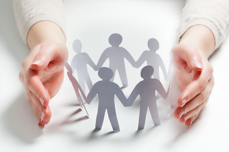 Paper people surrounded by hands in gesture of protection. Concept of insurance, social protection and support.