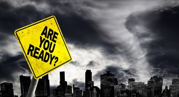 Protecting Your Condo or Co-op from the Next Major Storm Are You Ready warning sign against a powerful stormy background with city silhouette and copy space. Dirty and angled sign with cyclonic winds add to the drama. Created in Photoshop with photos of traffic sign, clouds and city skyline of Singapore that I shot on separate occasions (reference images attached)