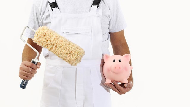 painter man with roller brush and piggy bank, isolated on white, saving concept
