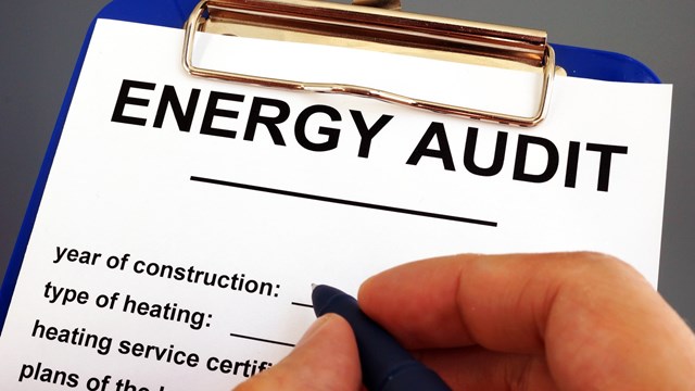 Man filling in energy audit form in a clipboard.