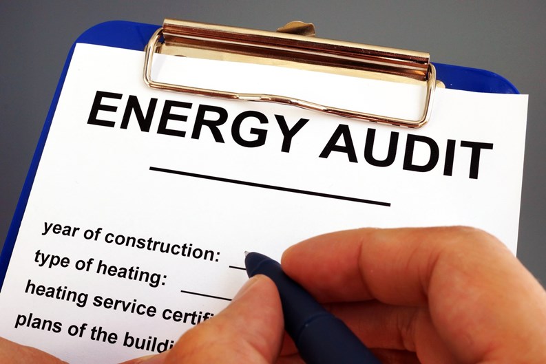 Man filling in energy audit form in a clipboard.