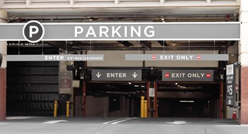 New Local Law Requires Parking Garage Inspections Parking sign in front of a parking garage downtown
