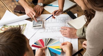 Capital Design Projects Architects team discussion on blueprints in office