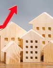 Miniature wooden houses and red arrow up. The concept of increasing the cost of housing. High demand for real estate. The growth of rent and mortgage rates. Sale of apartments. Population grows