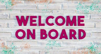 Onboarding New Board Members 3D letters in dark purple on a bright brick wall, with some colored paint-splatter.