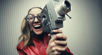 Q&A: Say Cheese? Nerdy woman using old fashioned cine camera