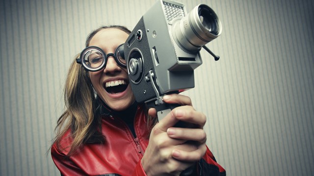 Nerdy woman using old fashioned cine camera