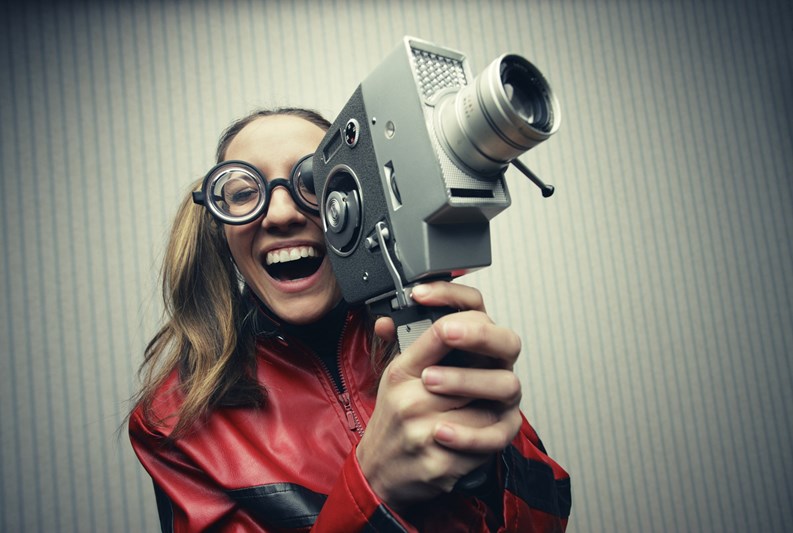 Nerdy woman using old fashioned cine camera