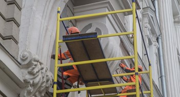 Workers restore the facade of an old building