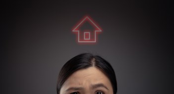 Unhappy Asian woman and home icon hologram effect. Isolated on background.