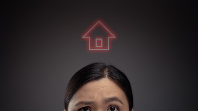 Unhappy Asian woman and home icon hologram effect. Isolated on background.