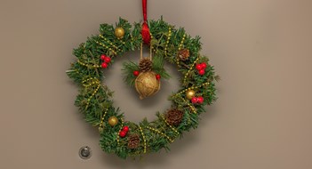 Close up view of Christmas wreath of spruce branches hanging on apartment front door.