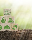 Climate-neutral long-term strategy greenhouse gas emissions targets Wooden block with green net center icon. Carbon neutral and net zero concept natural environment.