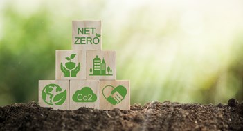 Climate-neutral long-term strategy greenhouse gas emissions targets Wooden block with green net center icon. Carbon neutral and net zero concept natural environment.