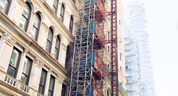 Looking up at the beautiful windows of a New York City Building. Construction scaffolding / elevator
