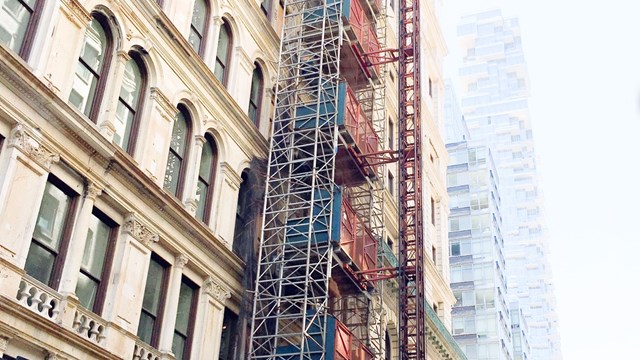 Looking up at the beautiful windows of a New York City Building. Construction scaffolding / elevator