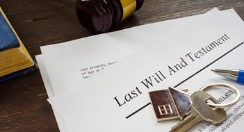 Last will and testament papers and key as symbol of property.