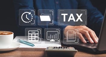 NYC Revenue Proposals Target Luxury Co-ops & Condos Businessman using a tax form to complete individual income tax payment form. Tax day concept.