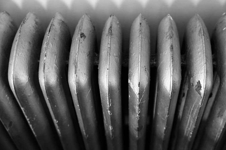 An old dark brown radiator in a kitchen
