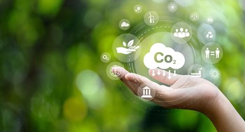 CO2 emission reduction concept in hand with environmental icons, global warming, sustainable development, connectivity and renewable energy green business background.