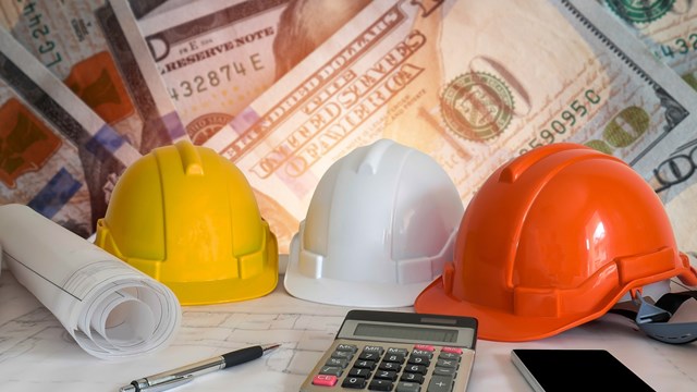 Architectural blueprint with safety helmet and tools on blur dollar money background.