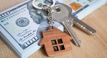 NAR Broker Fee Settlement Means Big Changes Real estate investing concept. American dollar, cash or housing. Keys close-up