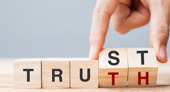 Corporate Transparency Act (CTA) Compliance Business man hand change wooden cube block with TRUST and TRUTH business word on table background. Trustworthy, faith, beliefs and honesty concept