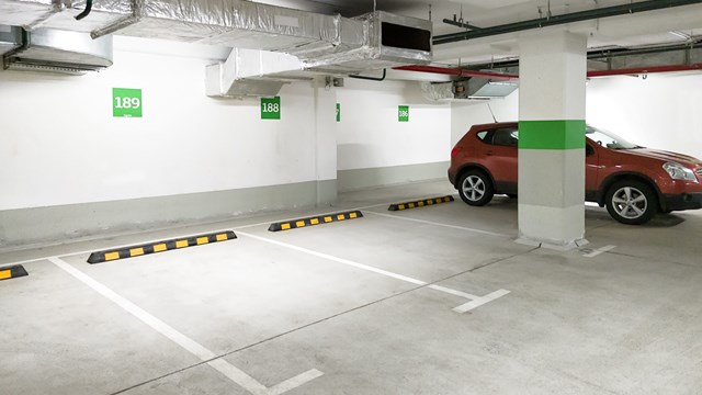 Underground car parking, empty modern parking lot indoor. Inside light parking garage in mall basement.