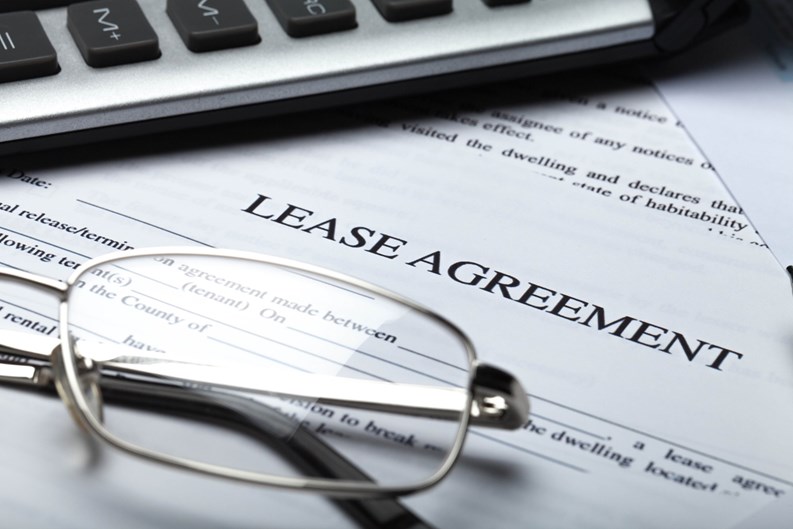 Lease Agreement Documents with Glasses, Pen and Calculator