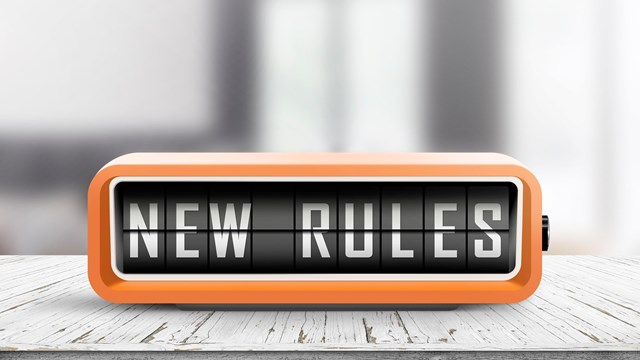 New rules alarm message on a wooden desk in a bright indoor environment