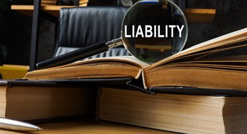 Labor Law 240/241 & the Cost of Liability Insurance in New York Legal liability concept. Law book and magnifying glass.