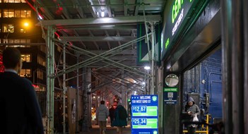 New Rules Lighten Up Sidewalk Sheds New York, NY, USA, 12-05-2023 New York City night time street scene with scaffolding parking garage entrance and pedestrians. Editorial use only.