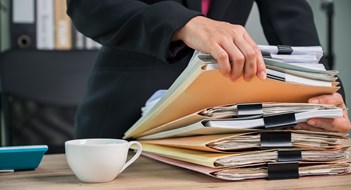 Just a Minute Close up Office employee working with documents at business desk in a business office