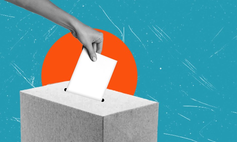 A hand is placing a blank ballot into a gray voting box, with a colorful blue backdrop featuring a sunburst, representing participation in democratic processes.