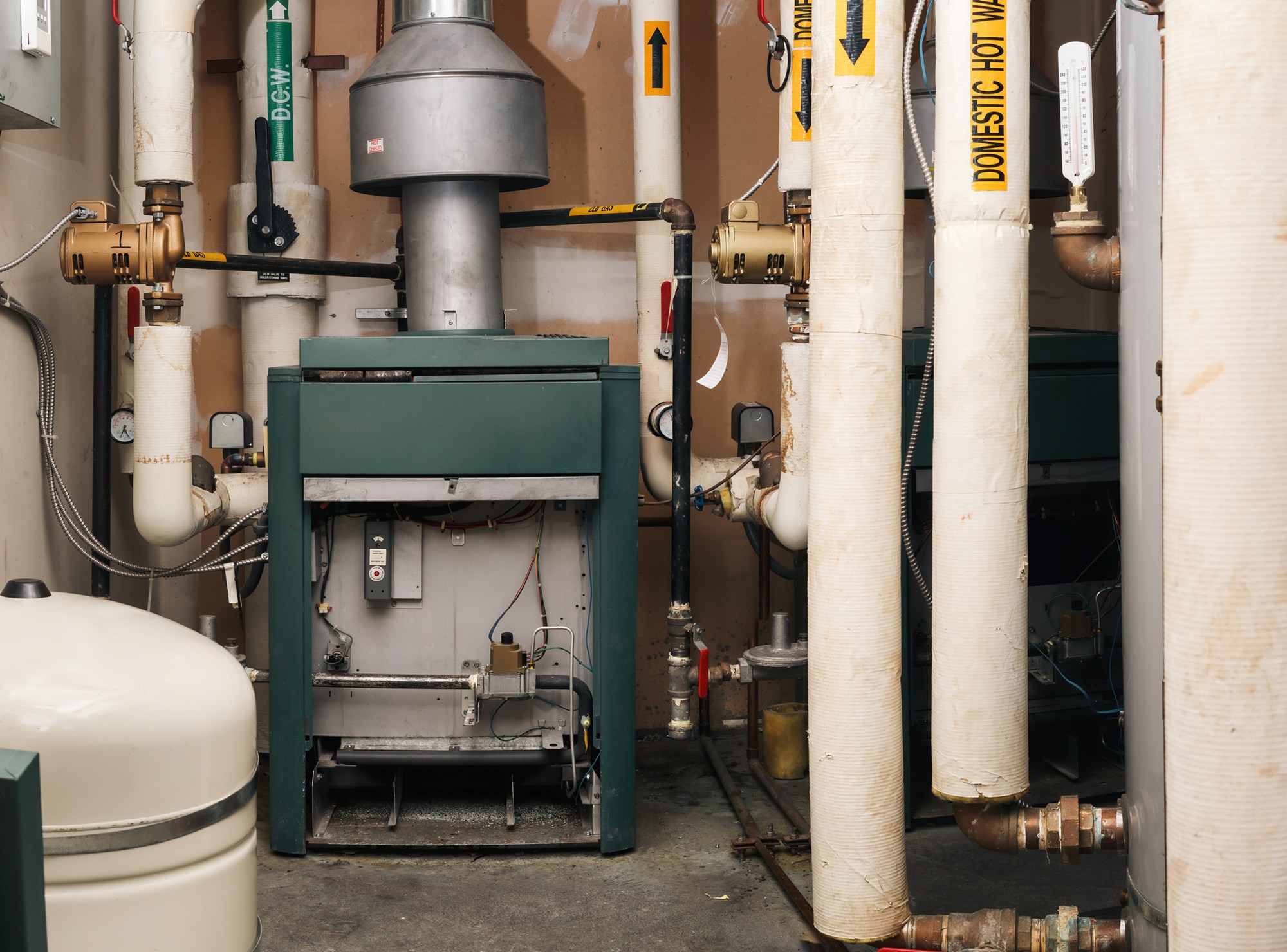 Natural gas heater, hot water tank and hot and cold water pipes. Gas safe, gas technician or plumbing background. Selective focus.