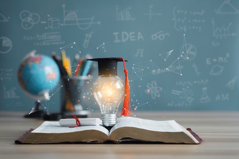Graduation cap with a lightbulb on the book and globe in the classroom. Education learning concepts in school or university. Idea knowledge of innovative technology, science, and mathematics.
