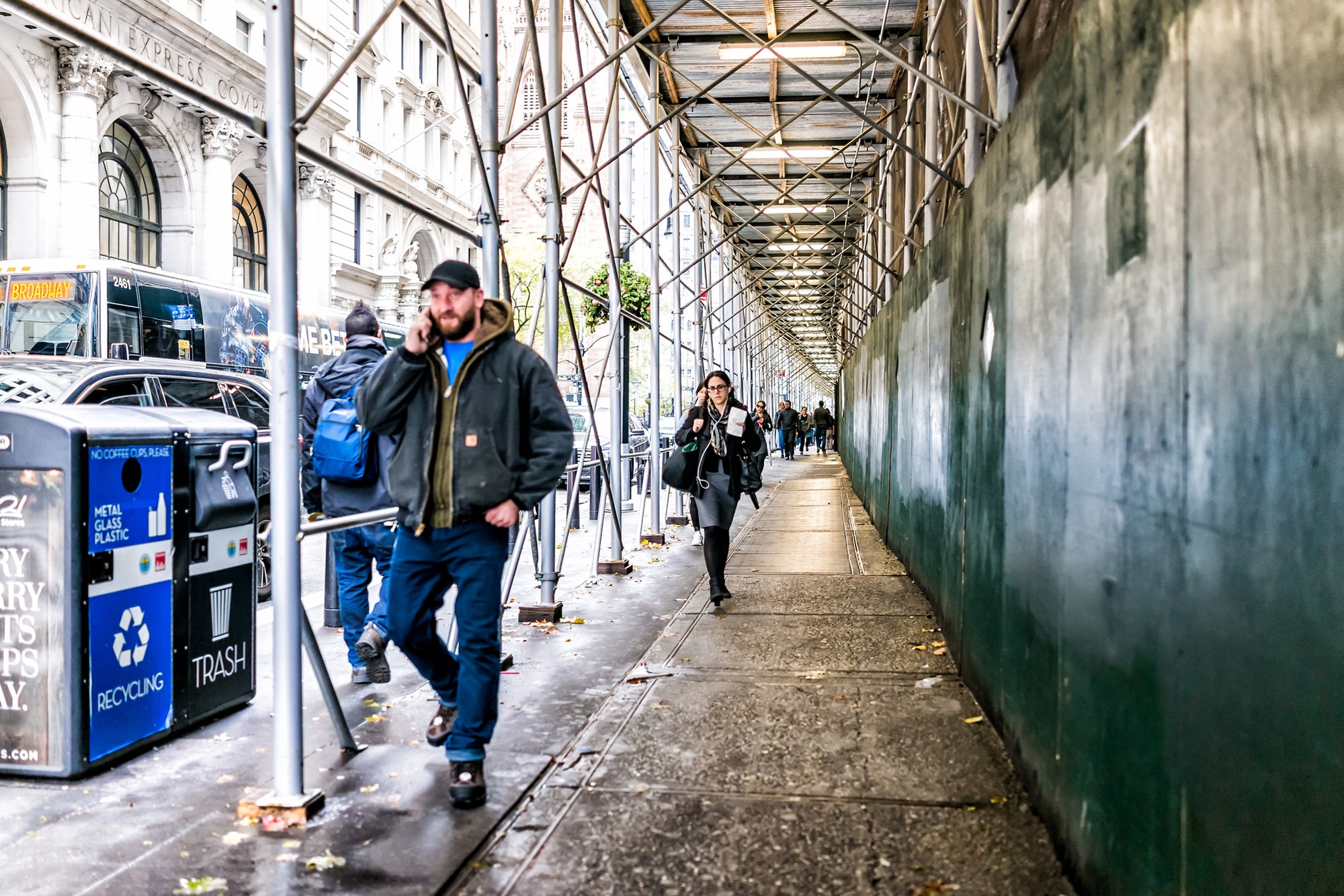 New York City, USA People walking under cover scaffold construction in NYC Manhattan 