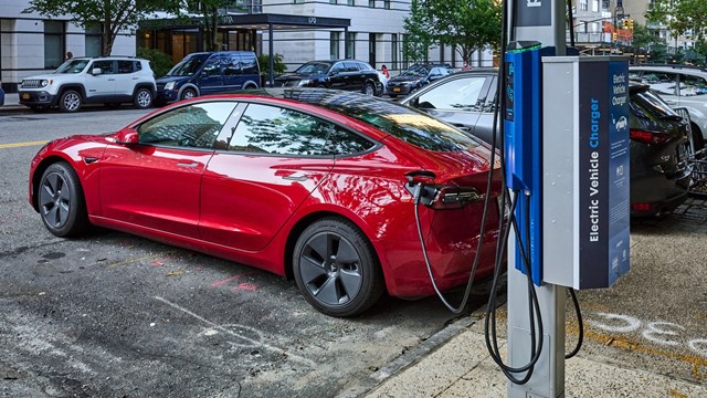 New York, NY - August 24, 2021: Recharging an electric car at a curbside NYC electric vehicle charger in the Upper East Side of NYC. This charger is provided by Flo in partnership with Con Edison and NYC DOT, (Department of Transportation)