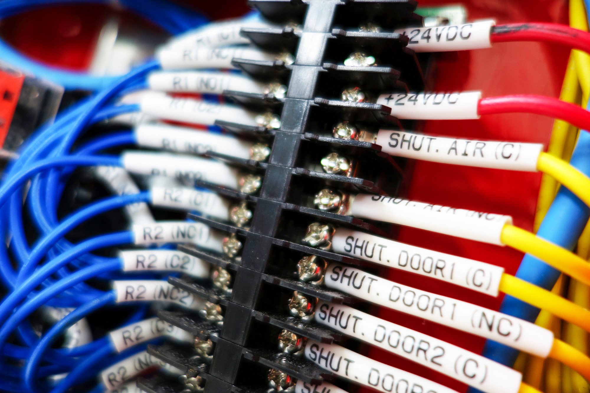 Close-up view of colorful wires and connectors in a control panel, showcasing intricate details of electrical connections and circuit structures.
