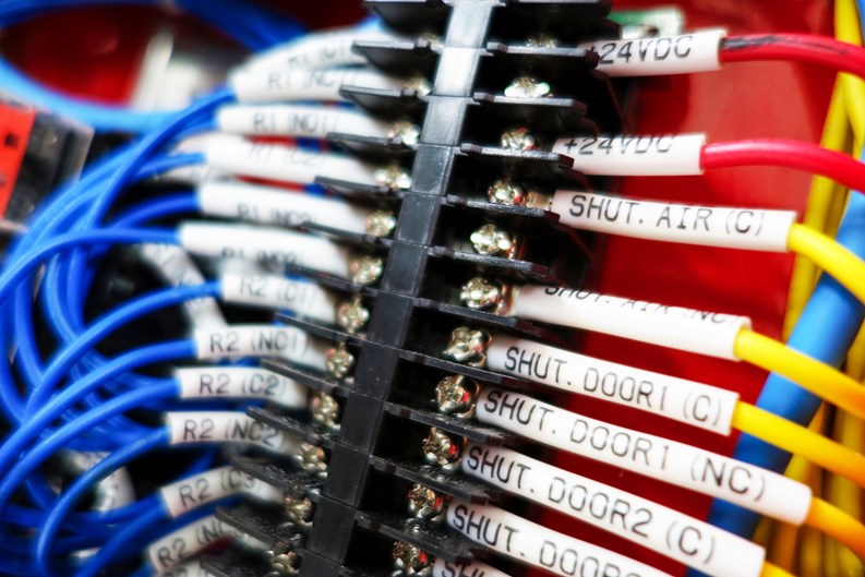 Close-up view of colorful wires and connectors in a control panel, showcasing intricate details of electrical connections and circuit structures.