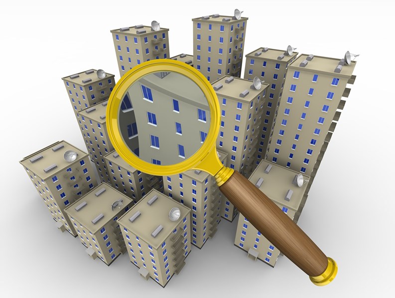 Multi-storey residential buildings on a white surface and loupe. The concept of real estate search. The three-dimensional illustration