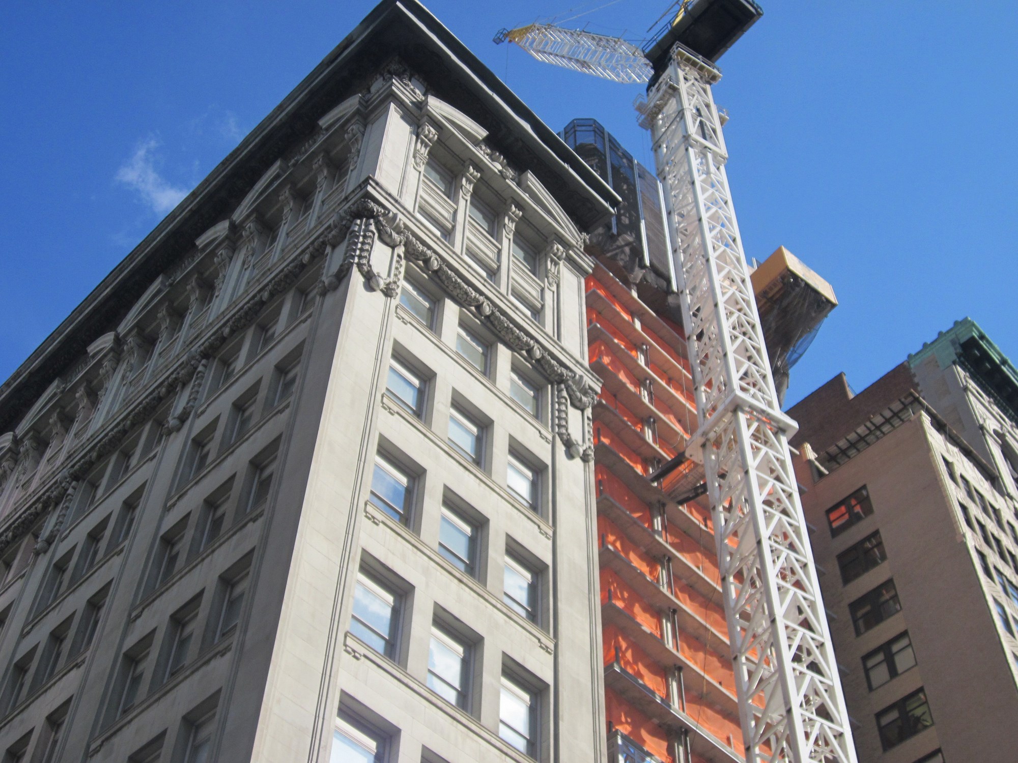 Shot taken of Manhattan building under construction during summer months.