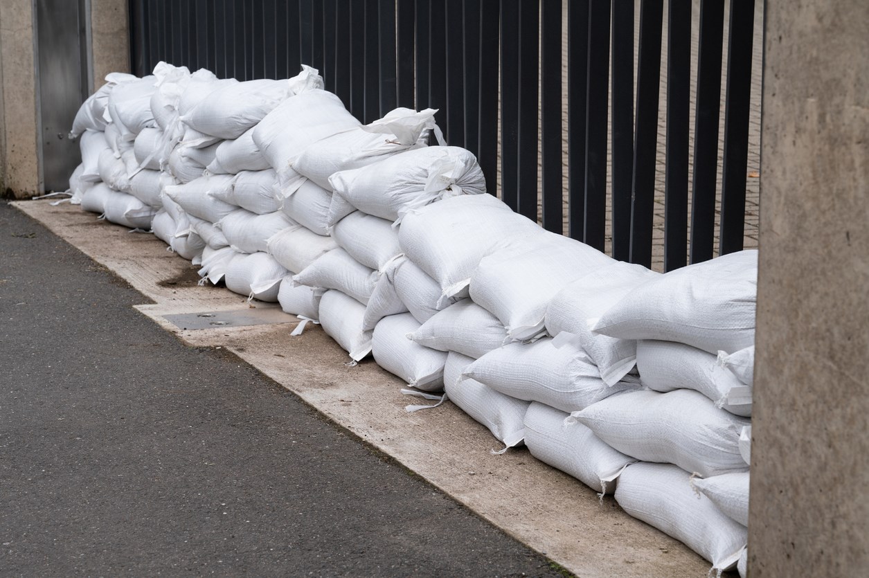 Sandbags for flood defense, river Moselle Trier in Rhineland Palatinate, flooded trees and paths, high water level, climate change